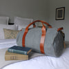 grey weekender bag on the bed